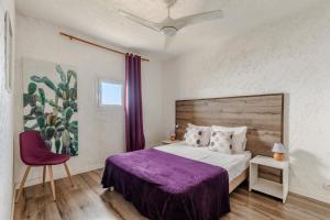 a bedroom with a large bed with a purple blanket at Résidence Marine de Palumbare in LʼÎle-Rousse +147 photos