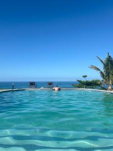 ein Schwimmbad mit dem Ozean im Hintergrund in der Unterkunft Bonito Bay in Cabo Nhabacal