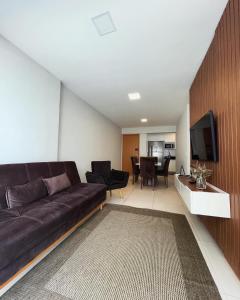 a living room with a black couch and a television at ITAPARICA BEACH CLUB in Vila Velha