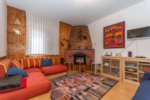a living room with a red couch and a fireplace at Casa Ciadenac in Soraga