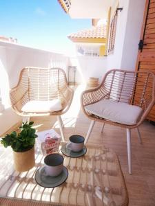 2 Stühle und ein Couchtisch auf einer Terrasse in der Unterkunft Słoneczny Apartament Parque IV in La Mata