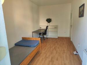 ein leeres Zimmer mit einem Schreibtisch und einem Bett in der Unterkunft 3 min walk to Bahnhof -Peaceful room with Balcony in Mannheim