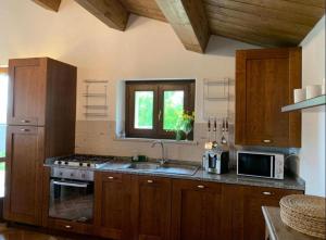 a kitchen with wooden cabinets and a sink and a window at Casa Raphael, Amandola in Amandola