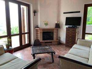 a living room with a fireplace and a tv at Casa Raphael, Amandola in Amandola