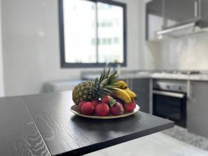 a plate of fruit on a table in a kitchen at Modern & Cosy Studio City Center in Kenitra