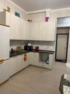 a kitchen with white cabinets and a black counter top at Елисаветинская 15 in Odesa