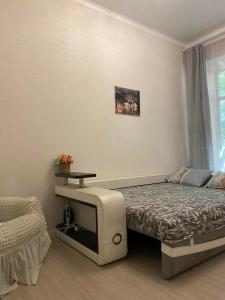 a bedroom with a bed and a table and a window at Елисаветинская 15 in Odesa