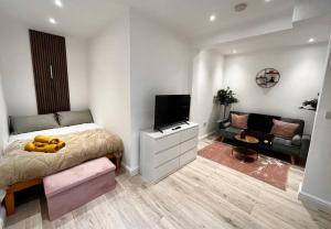a bedroom with a bed and a flat screen tv at Modern Boutique Apartment Great Location in Golders Green