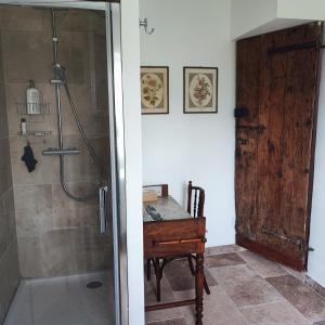 een badkamer met een douche, een tafel en een bureau bij Magnanerie de Sainte Croix in Saint-Hippolyte-de-Caton