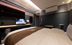 a hotel room with a large bed and a television at Hotel in Cafe Doksan in Seoul