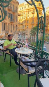 een man aan een tafel op een patio bij Cairo Inn in Caïro