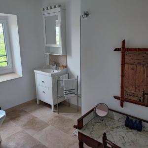 een badkamer met een wastafel, een toilet en een spiegel bij Magnanerie de Sainte Croix in Saint-Hippolyte-de-Caton