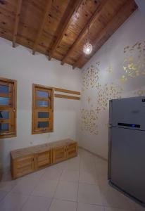 a kitchen with a stainless steel refrigerator and wooden cabinets at Lighthouse Apartment in Dahab