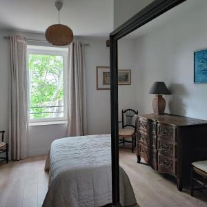 een slaapkamer met een bed, een dressoir en een raam bij Magnanerie de Sainte Croix in Saint-Hippolyte-de-Caton