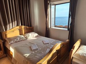 a bedroom with a bed with a view of the ocean at Guest house Naser in Ulcinj