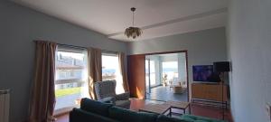 a living room with a couch and a large window at Apartamento El Xardín in Cabrafigal