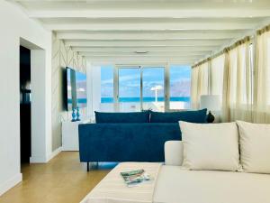 a living room with a blue couch and large windows at Canaryislandshost I Marino in Famara