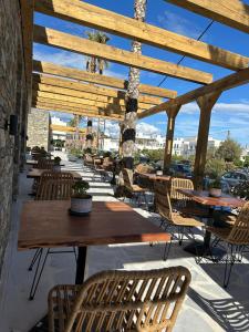 an outdoor patio with wooden tables and chairs at Cavo piso livadi in Piso Livadi