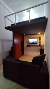 Habitación con cama elevada y TV en la pared. en AN Homestay, en Wonosobo