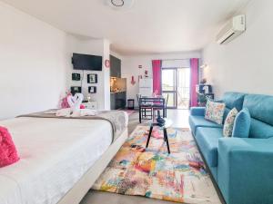 a bedroom with a bed and a blue couch at Apartments Edifício Cruzeiro in Portimão