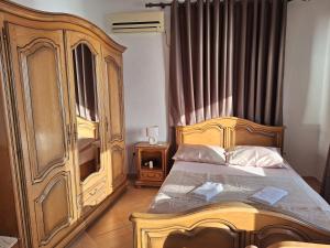 um quarto com uma cama de madeira e um armário de madeira em Guest house Naser em Ulcinj