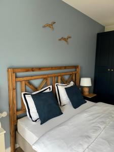 sypialnia z łóżkiem z 2 niebiesko-białymi poduszkami w obiekcie Apartament No 11 - HOME APART w Ostródzie