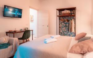 sypialnia z 2 łóżkami, biurkiem i telewizorem w obiekcie Pascià Madonna Rocca w Taominie