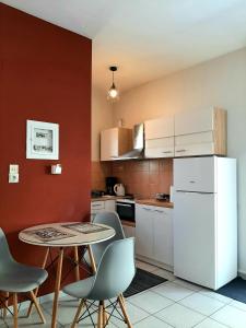 a kitchen with a table and chairs and a white refrigerator at Crystal Cherry Apartment in Preveza