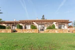 una casa con una pared de piedra y un patio en Agroturismo Can Pere Rei, en Son Serra de Marina