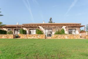 a house with a stone wall and a yard at Agroturismo Can Pere Rei in Son Serra de Marina