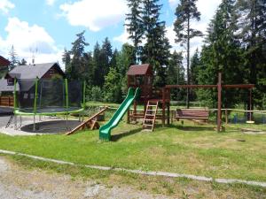 um parque infantil com escorrega e um baloiço em Hotel Polovnik em Demanovska Dolina