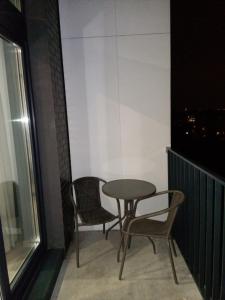 stół i krzesła w pokoju z oknem w obiekcie Lux Lotnisko we Wrocławiu