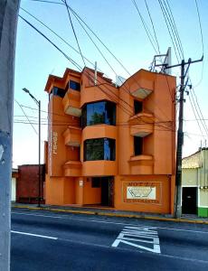 een oranje gebouw aan de straatkant bij Hotel Los Diamantes Orizaba in Orizaba