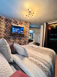 een slaapkamer met een groot bed en een tv aan de muur bij Hotel Los Diamantes Orizaba in Orizaba