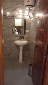een badkamer met een wastafel en een spiegel bij HOTEL THE PINE VILLA MUSSOORIE in Mussoorie