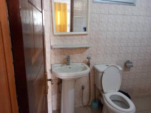 a small bathroom with a toilet and a sink at fleur in Dakar