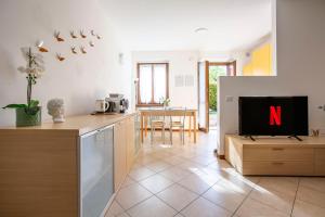 a living room with a tv and a kitchen at Lake Como Getaway - Central, Lake nearby - Parking & private garden in Mandello del Lario