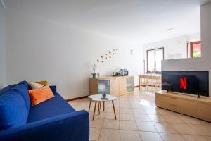 a living room with a blue couch and a tv at Lake Como Getaway - Central, Lake nearby - Parking & private garden in Mandello del Lario