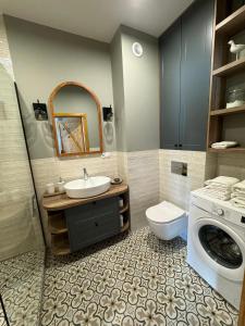 łazienka z umywalką i pralką w obiekcie Apartament No 11 - HOME APART w Ostródzie