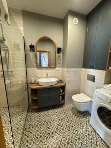 łazienka z umywalką i pralką w obiekcie Apartament No 11 - HOME APART w Ostródzie