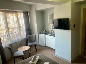 una habitación de hotel con TV encima de una nevera en Last Point Süit Apart, en Eskisehir