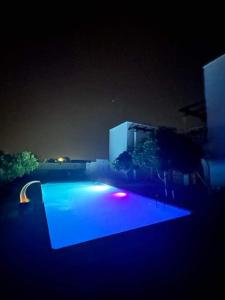 una piscina iluminada por la noche con luces azules en Résidence Jlidi, en Midoun
