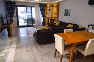 ein Wohnzimmer mit einem Sofa und einem Tisch in der Unterkunft Çeşmede sakin lüks havuzlu villa in Cesme