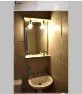un baño con lavabo y espejo en Asturias, en Presidencia Roque Sáenz Peña
