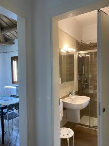ein Bad mit einem Waschbecken und einem Spiegel in der Unterkunft Holiday Home Giaron in Rosolina