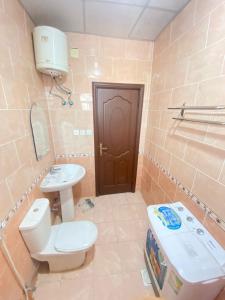 a bathroom with a toilet and a sink at أجــنــحــة وتــيــن in Al Madinah