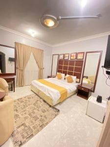 een slaapkamer met een bed en een televisie. bij أجــنــحــة وتــيــن in Al Madinah