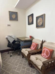 バラナシにあるStay At The Homeのデスク、テーブル、椅子が備わる客室です。