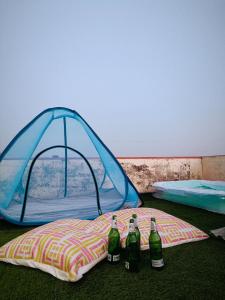 a tent with four bottles on a pillow at Stay At The Home in Varanasi