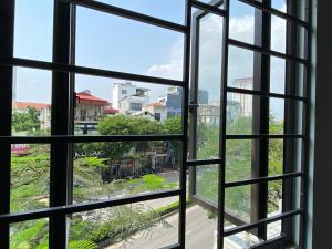 ein offenes Fenster mit Stadtblick in der Unterkunft Pan Housing Hostel & Residence in Hanoi